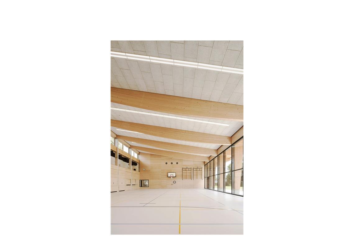 Junge Stuttgarter Architekten entwerfen ein Haus fürs ganze Dorf . . . nach dem Umbau. Links wurde die Wand geöffnet, es kam eine Empore hinzu – die Holzbinder mit der geschwungenen Unterseite „rhythmisieren den Hallenraum“, sagt Architekt Kilian Juraschitz. Festlich wirken lassen sie ihn außerdem. Die hellen Sauerkrautplatten sorgen für gute Akustik.