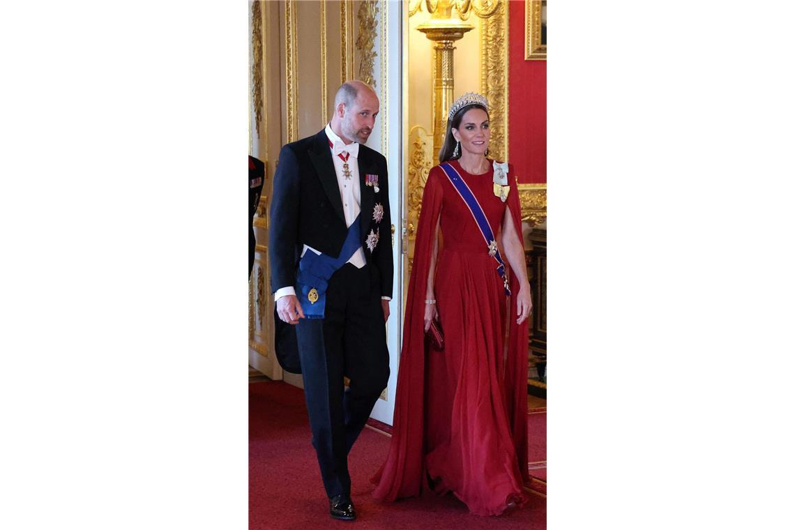 Charmant oder frech? Macron zwinkert Prinzessin Kate zu ... rouge: Prinz Williams Frau Kate macht die Modediplomatie in einem karminroten Givenchy-Kleid komplett.