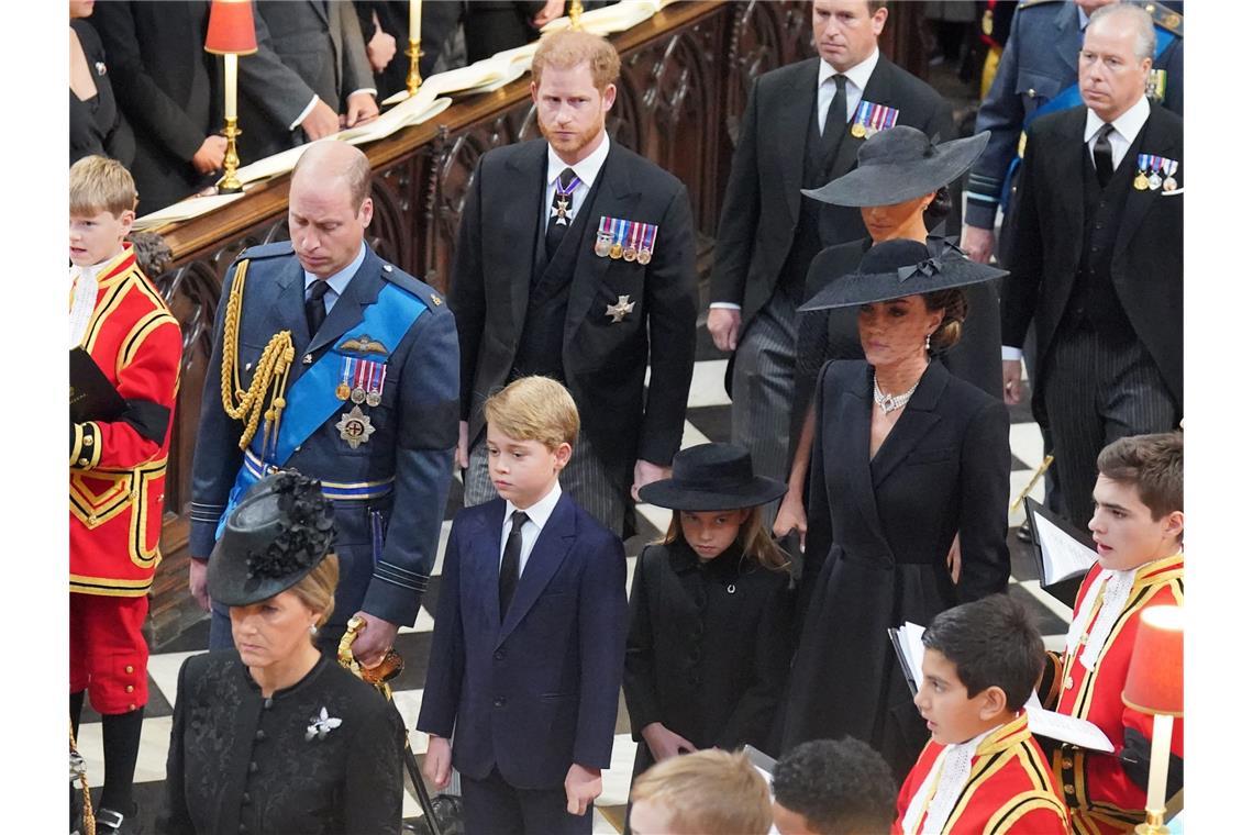 2022 stirbt Queen Elizabeth II. Prinz William (vorne l-r), Prinz von Wales, und sein Sohn Prinz George, seine Tochter Prinzessin Charlotte, und seine Frau Kate, Prinzessin von Wales, und dahinter Prinz Harry, Herzog von Sussex, und seine Frau Meghan, Herzogin von Sussex, kommen zum Staatsakt vor der Beisetzung von Königin Elizabeth II. in der Westminster Abbey.