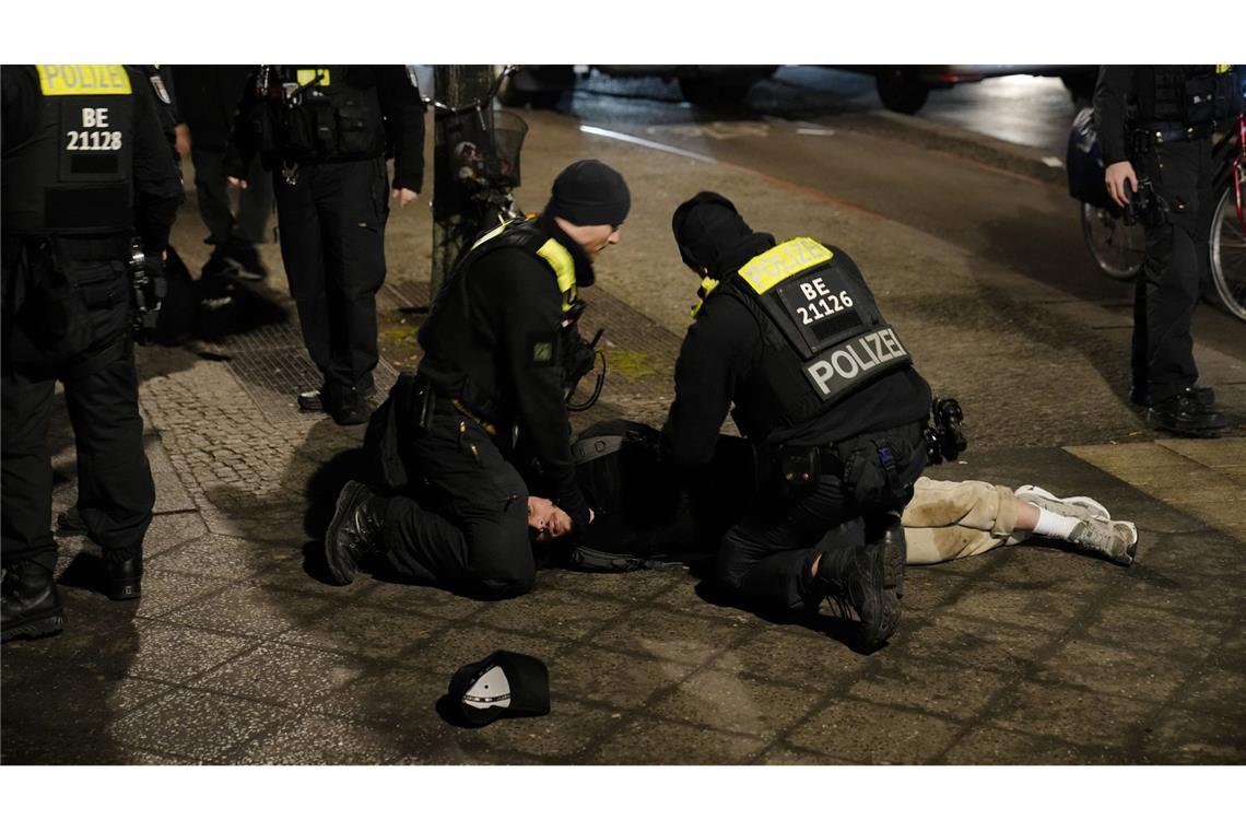 21.02.2025, Berlin: Polizeibeamte halten einen Mann am Holocaust-Mahnmal fest, nachdem ein anderer Mann schwer verletzt wurde.