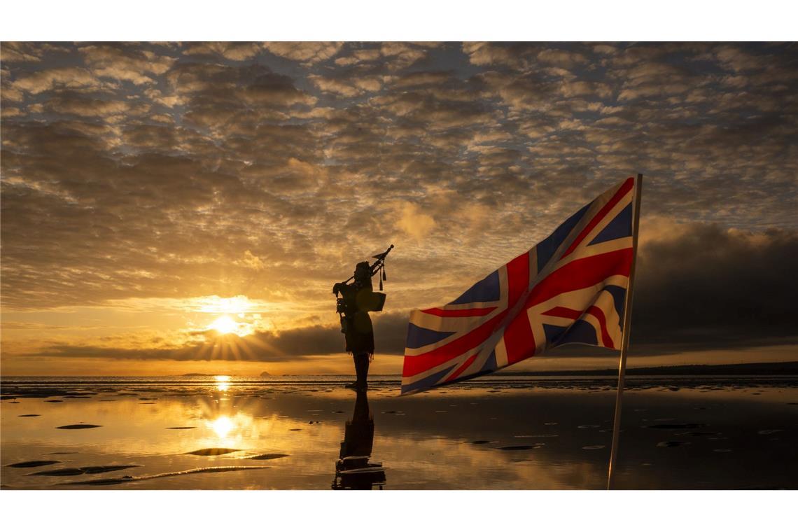Bilder des Tages 80. Jahrestag Ende Zweiter Weltkrieg - Edinburgh: Die schottische Nationalpfeiferin Louise Marshall spielt in der Morgendämmerung am Portobello Beach mit Blick auf den Firth of Forth ein Klagelied auf die Gefallenen zum 80. Jahrestag des Endes des Zweiten Weltkriegs.