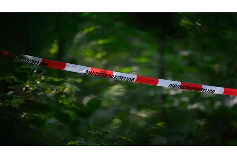 Absperrband der Polizei ist in einem Wald gespannt. (Symbolbild)