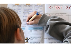 ADHS kann Probleme in der Schule auslösen: In einer Grundschule arbeitet ein Schüler einer vierten Klasse an in einem Heft an seinen Mathematikaufgaben.