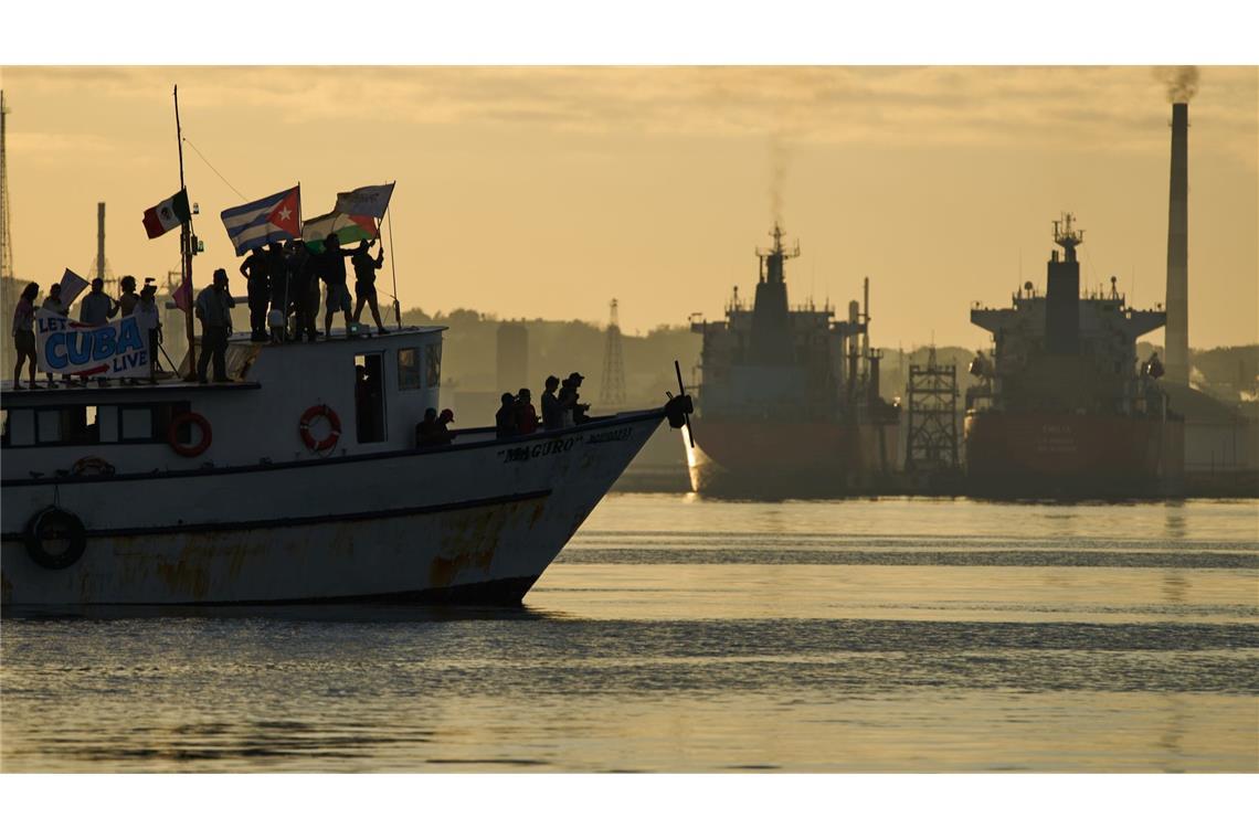Aktivisten schwenken kubanische und palästinensische Fahnen auf dem Schiff "Maguro", das im Rahmen des Konvois "Nuestra America" (Unser Amerika) aus Mexiko mit humanitärer Hilfe eintrifft, in der Bucht von Havanna.