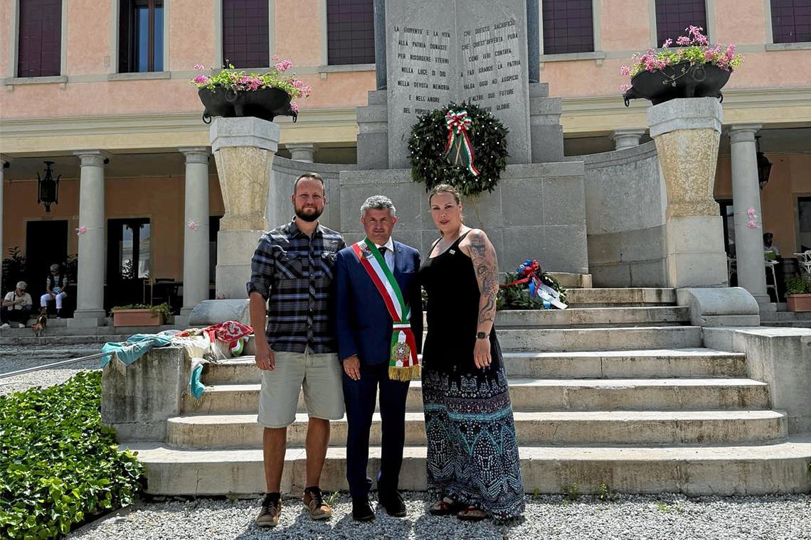 Austausch in Sachen Fasnet und Karneval angedacht Alexander Irion und Julia Piechot mit Bürgermeister Stefano Soldan (Mitte) vor dem Denkmal zur Erinnerung an die Gefallenen der beiden Weltkriege. Foto: Murreder Henderwäldler