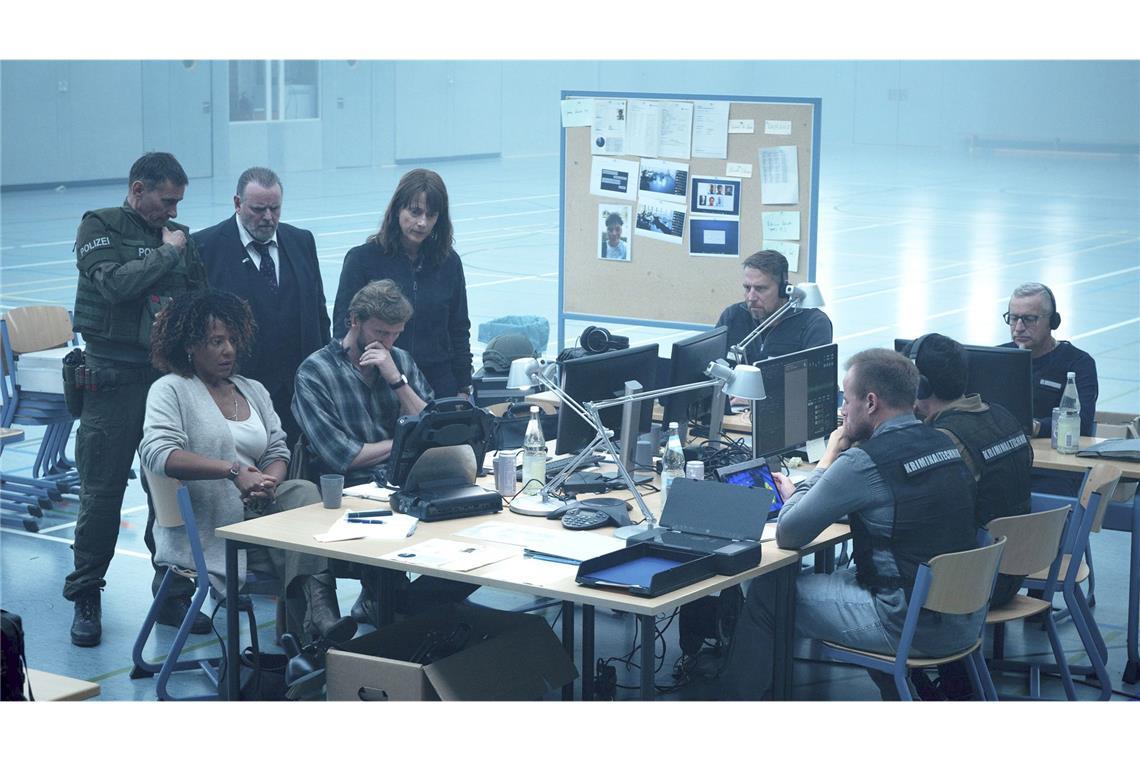 „Sie sind unter uns“ – Wie war der Polizeiruf aus Magdeburg? Alle sehen über die Monitore wie Jeremy die Waffe auf eine Geisel richtet (v.l.): Petra Giese (Anja Herden), Einsatzleiter SEK (Frank Schilcher), Lemp (Felix Vörtler), Karsten Nötzing (Ulrich Brandhoff) und Brasch (Claudia Michelsen)