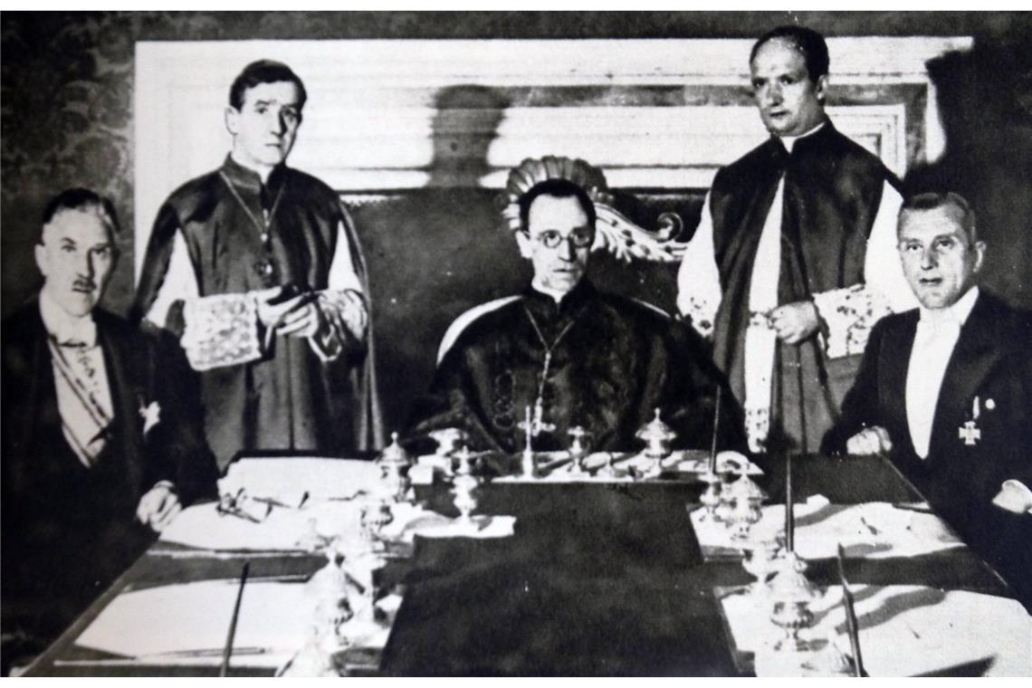 Am 20. Juli 1933 unterzeichnen Kardinalstaatssekretär Eugenio Pacelli und Franz von Papen das Reichskonkordat zwischen dem Deutschen Reich und dem Heiligen Stuhl (auf dem Foto sind zu sehen von links nach rechts: Prälat Ludwig Kaas, Vizekanzler Franz von Papen, Unterstaatssekretär Giuseppe Pizzardo, Kardinalstaatssekretär Eugenio Pacelli und Ministerialdirektor Rudolf Buttmann während des Unterzeichnungsaktes; zwischen Pacelli und Buttmann stehend: Substitut Alfredo Ottaviani.