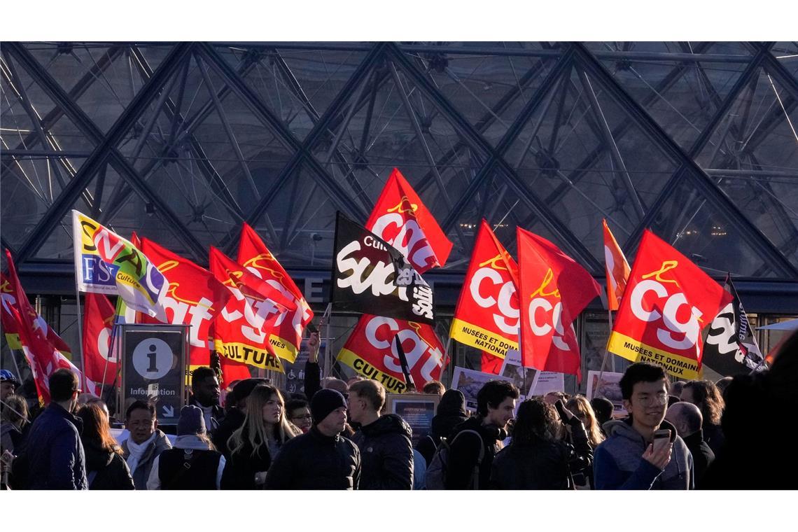 Angestellte zeigen Fahnen der Gewerkschaft CGT vor dem Louvre.