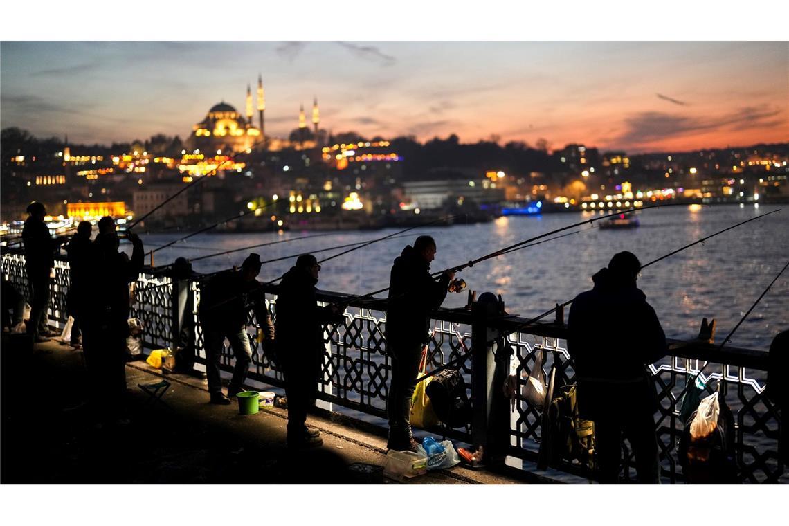 Bilder des Tages Angler in Istanbul fischen nach frischem Fisch bei Sonnenuntergang auf der Galata-Brücke über den Bosporus.