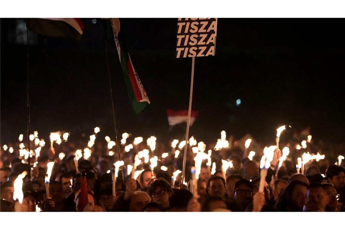 Anhänger von Peter Magyar, dem Vorsitzenden der oppositionellen Tisza-Partei, halten bei der Wahlkampfveranstaltung ihre beleuchteten Handys hoch.