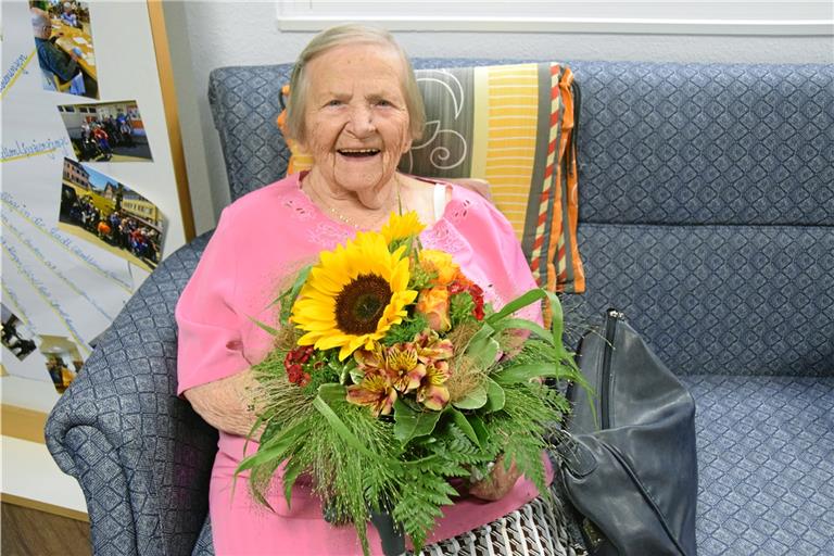 Anni Erlenbusch freut sich über einen großen Blumenstrauß zu ihrem 100. Geburtstag, den sie in der Tagespflege nachfeiert. Foto: Elisabeth Klaper