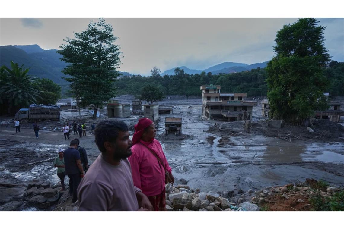Anwohner betrachten die Verwüstungen, die Sturzfluten im nepalesischen Distrikt Nuwakot hinterlassen haben.