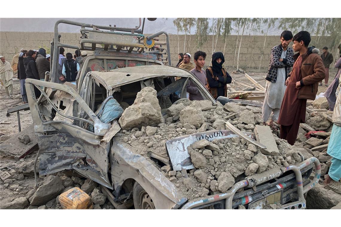Anwohner stehen neben einem beschädigten Auto am Ort eines grenzüberschreitenden Angriffs der pakistanischen Armee in der Provinz Nangarhar. (Archivbild)