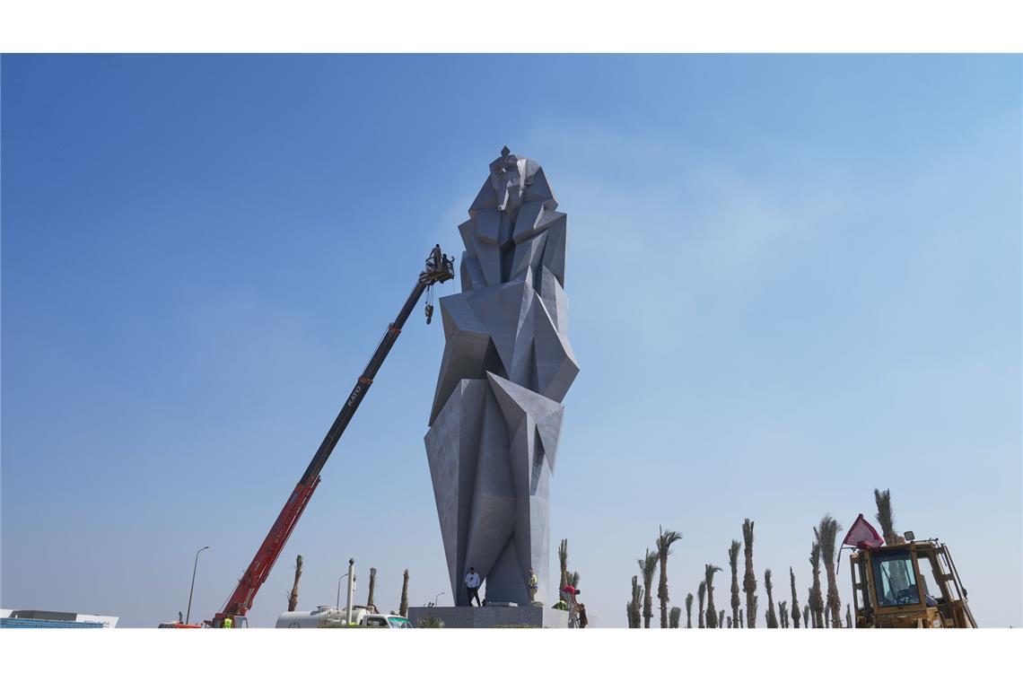 Bilder des Tages Arbeiter bemalen die 27 Meter hohe Eisenstatue "The Guard" des ägyptischen Künstlers Deyaa Awed. Die Statue steht den Besuchern gegenübersteht, die vom Flughafen Sphinx zum Großen Ägyptischen Museum kommen.