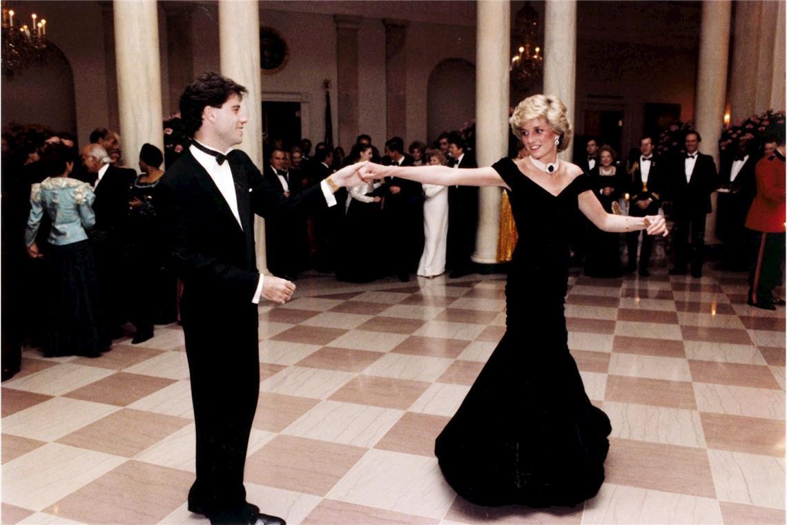 Archivfoto vom November 1985, das Diana beim Tanzen mit dem Hollywood-Schauspieler John Travolta während einer Feier im Weißen Haus im Jahr 1985 zeigt, die vom damaligen US-Präsidenten Ronald Reagan und seiner Frau Nancy ausgerichtet wurde. Das Kleid wurde 1997 für wohltätige Zwecke für 100.000 Pfund Sterling versteigert. 2013 wurde es erneut versteigert: Für 240.000 Pfund Sterling.