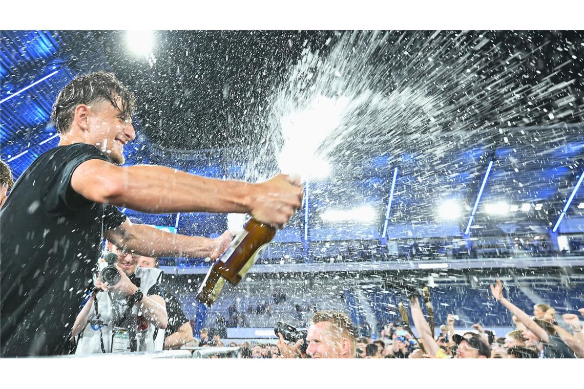 Arena. Spieler von SC Paderborn 07 spritzt mit einer Sektflasche im Stadion.