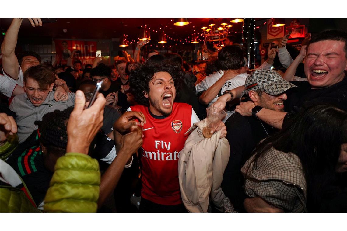 Arsenal-Anhänger feiern in einem Pub in der Nähe des Arsenal-Stadions, nachdem die Fußballmannschaft des FC Arsenal den Titel in der Premier League gewonnen hat.