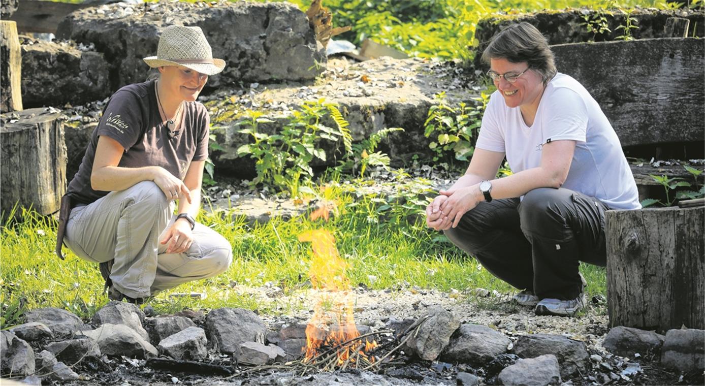 Astrid Szelest hat Redakteurin Christine Schick (von links) auf die Probe gestellt: Mit nur einem Streichholz ein Feuer entfachen. Die Freude ist groß, als es geklappt hat.
