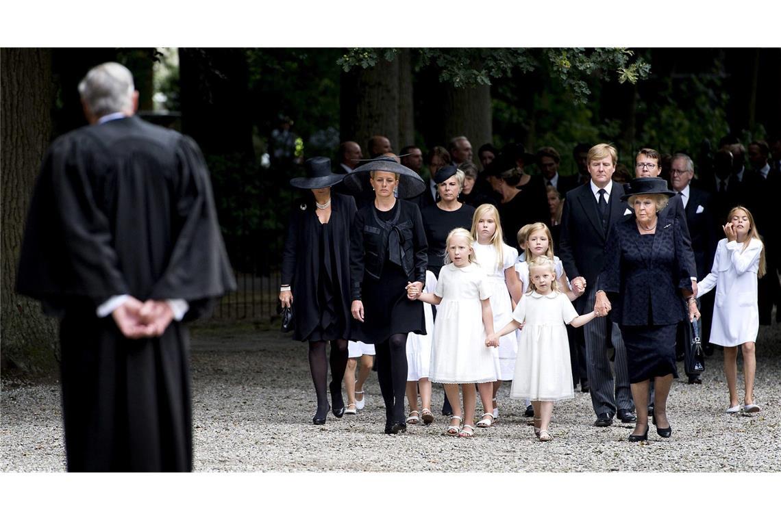 Auch 2013: Prinz Friso, Bruder des Königs, stirbt an den Folgen eines Lawinenunglücks, das sich 2012 im österreichischen Lech zugetragen hat. Vorne gehen Frisos Frau Mabel Wisse-Smit, seine Töchter Prinzessin Luana und Prinzessin Zaria sowie die ehemalige Königin Beatrix, dahinter folgen Königin Maxima, Prinzessin Amalia, Prinzessin Alexia, König Willem-Alexander und weitere Trauergäste. Friso wurde auf dem Friedhof an der Stulpkerk in Lage Vuursche, welcher an das Schloss Drakensteyn angrenzt, beigesetzt.
