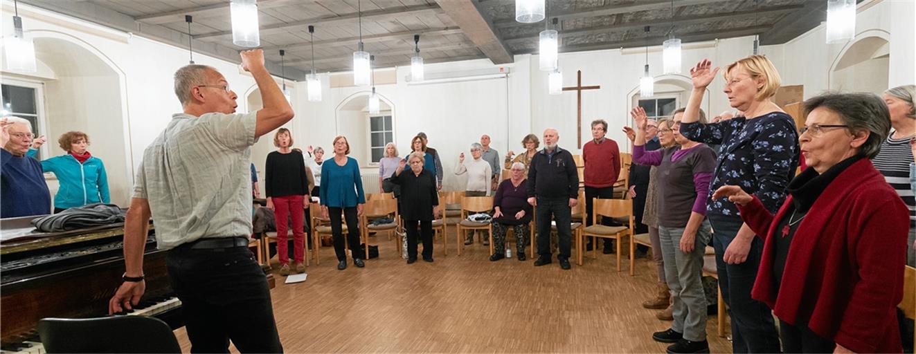 Auch beim Singen heißt es, sich warmzulaufen: Kantor Gottfried Mayer (vorne links) stimmt die Mitglieder der Kantorei bei ihrer Probe in der Alten Abtei mit ersten Lockerungsübungen ein. Der Chor gestaltet am Sonntag beim Festgottesdienst zum Jubiläum eine adventliche Chormusik. Fotos: J. Fiedler