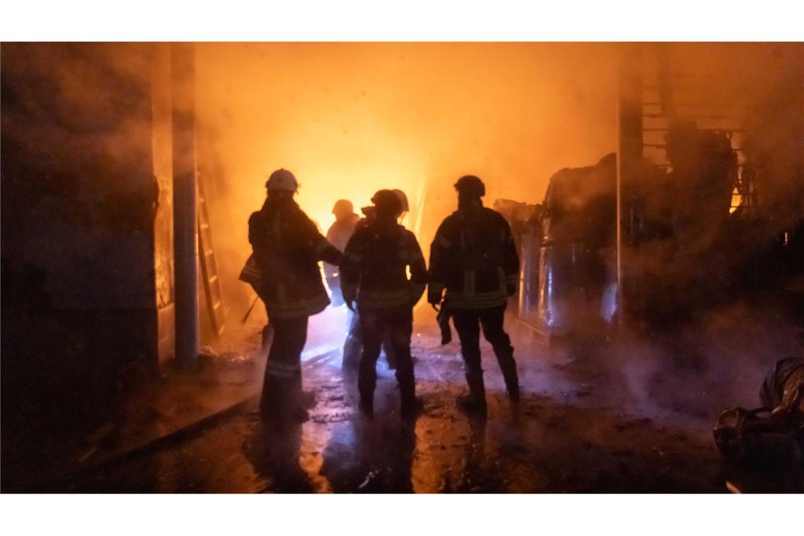 Mehr als 20 Tote nach Angriffen in der Ukraine und Russland Auch in Charkiw gab es russische Angriffe. Feuerwehrleute löschen einen Brand in einer Fabrik.