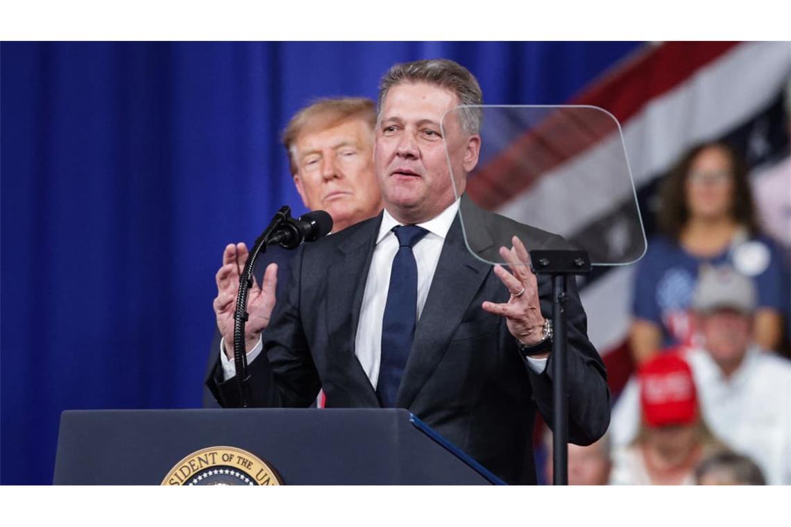 Audi-CEO Gernot Döllner trat ans Mikrofon, während US-Präsident Donald Trump hinter im zuhörte.
