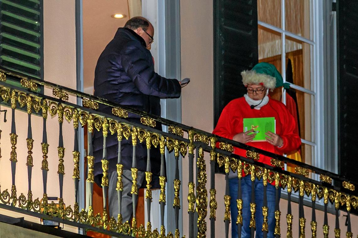 Auf dem Balkon des Rathauses unterhalten sich Bürgermeister und Sandmännchen.