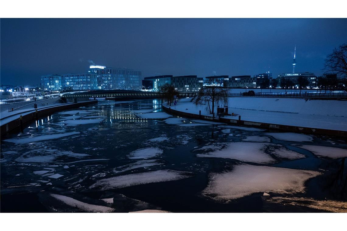 Auf der Spree in BErlin schwimmen verschneite Eisschollen.