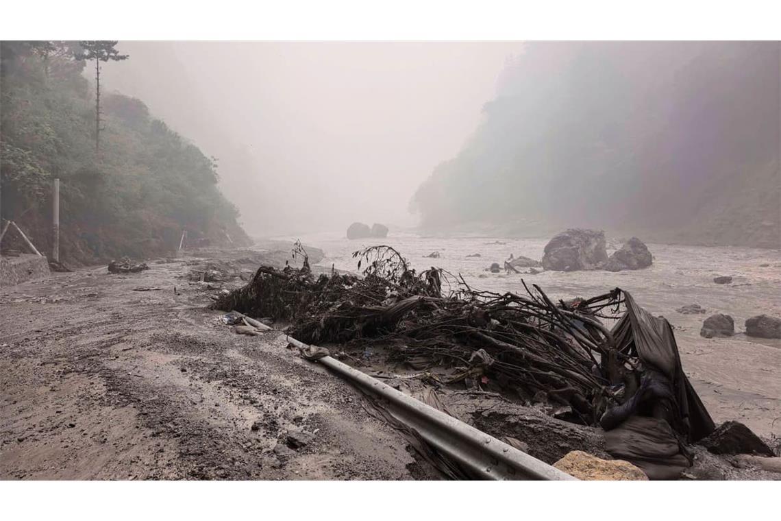 Auf diesem von der Nachrichtenagentur Xinhua veröffentlichten Foto ist ein schlammiges Flussufer mit Trümmern in der Nähe des Hafens von Gyirong in der Autonomen Region Tibet im Südwesten Chinas zu sehen.