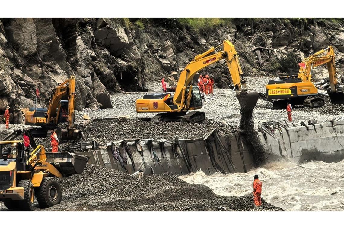 Auf diesem von der Nachrichtenagentur Xinhua veröffentlichten Foto sind Rettungskräfte zu sehen, die mit schwerem Gerät eine Straße freiräumen, die zu den von Schlammlawinen betroffenen Gebieten in Xigaze in der Autonomen Region Tibet im Südwesten Chinas führt.