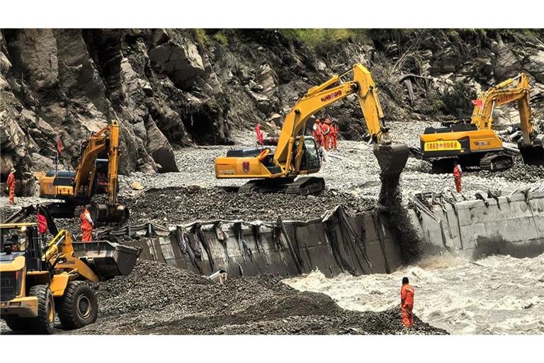Auf diesem von der Nachrichtenagentur Xinhua veröffentlichten Foto sind Rettungskräfte zu sehen, die mit schwerem Gerät eine Straße freiräumen, die zu den von Schlammlawinen betroffenen Gebieten in Xigaze in der Autonomen Region Tibet im Südwesten Chinas führt.