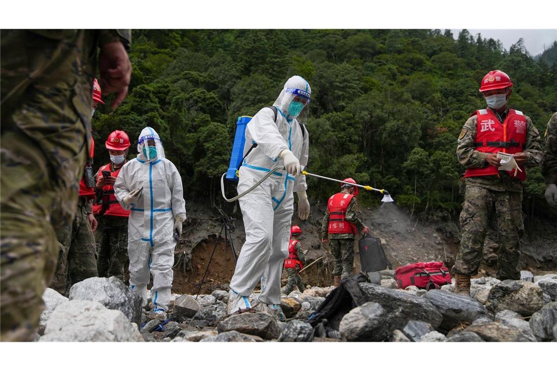 Auf diesem von der Nachrichtenagentur Xinhua veröffentlichten Foto führt ein Arbeiter Desinfektionsarbeiten durch, während Rettungskräfte in einem von der Schlammlawinenkatastrophe betroffenen Gebiet im Kreis Gyirong in der Autonomen Region Tibet im Südwesten Chinas nach Opfern suchen. (zu dpa: «Überall Leichensäcke: Mehr als 1.000 Tote nach Himalaya-Flut»)