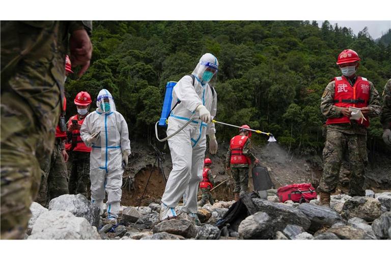 Auf diesem von der Nachrichtenagentur Xinhua veröffentlichten Foto führt ein Arbeiter Desinfektionsarbeiten durch, während Rettungskräfte in einem von der Schlammlawinenkatastrophe betroffenen Gebiet im Kreis Gyirong in der Autonomen Region Tibet im Südwesten Chinas nach Opfern suchen. (zu dpa: «Überall Leichensäcke: Mehr als 1.000 Tote nach Himalaya-Flut»)