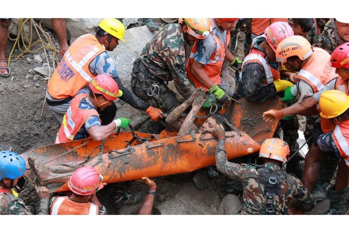Auf diesem von der nepalesischen Armee zur Verfügung gestellten Foto retten Soldaten im Rahmen einer laufenden Rettungsaktion am Wasserkraftprojekt Trishuli 3A im nepalesischen Distrikt Rasuwa einen Arbeiter lebend aus einem Tunnel. 