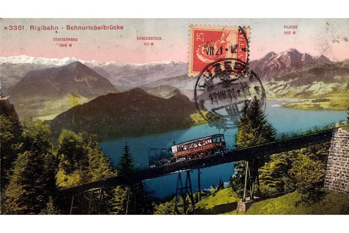 Die Rigibahn fährt als Europas erste Zahnradbahn auf einen Berggipfel Auf dieser Postkarte von 1935 ist die Rigibahn zu sehen, wie sie die Schnurtobelbrücke überquert. Im Hintergrund ist der Vierwaldstättersee bei Luzern zu sehen.