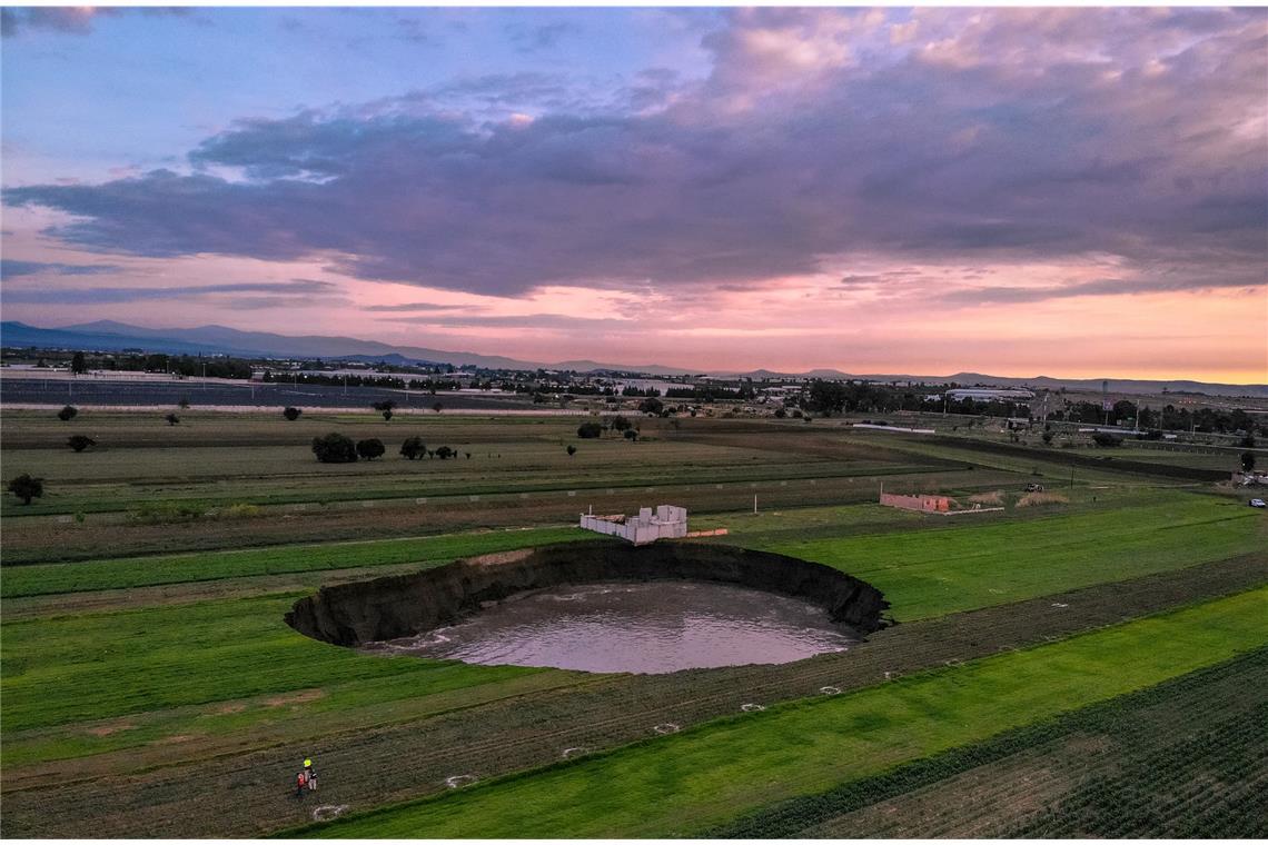 Riesiger Krater in Mexiko gibt Rätsel auf Auf einem Feld bei dem Ort Santa Maria Zacatepec ist der mit Wasser gefüllte Krater zu sehen.