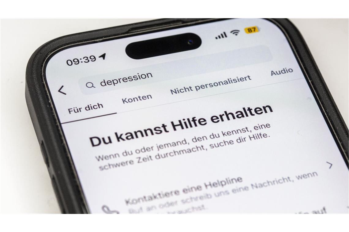 Auf einem Smartphone ist eine Suchansicht innerhalb einer Social-Media-App zu sehen, die bei dem Begriff „Depression“ Hinweise auf Hilfsangebote und Unterstützung einblendet. Plattformen wie Instagram zeigen bei sensiblen Suchbegriffen zunehmend Sicherheitshinweise und Verlinkungen zu professionellen Beratungsstellen. Sie reagieren damit auf die wachsende Rolle sozialer Medien bei der Informationssuche zu psychischen Belastungen.