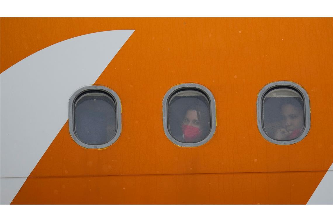 Bilder des Tages Aus den Vereinigten Staaten abgeschobene venezolanische Migranten schauen nach der Landung auf dem internationalen Flughafen Simon Bolivar in Maiquetia, Venezuela, aus den Bullaugen ihres Flugzeugs.