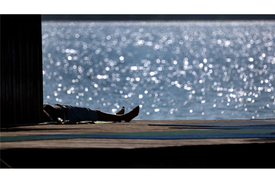 Die Hitze kommt: Temperaturen bis 35 Grad Ausflügler genießen auf dem Steg des Strandbades am Ammersee in Bayern den Sonnenschein.