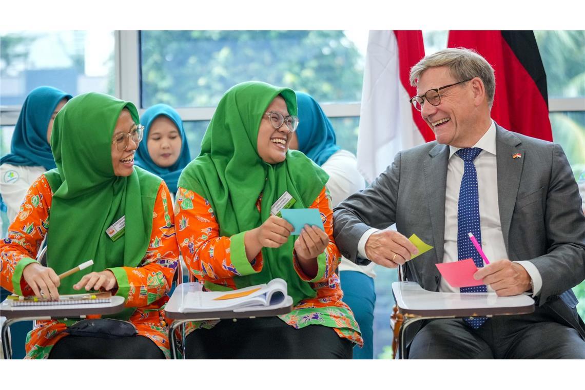 Außenminister Johann Wadephul scherzt bei seinem Besuch in Indonesien in einer Fachschule für Gesundheitsberufe mit Studentinnen.