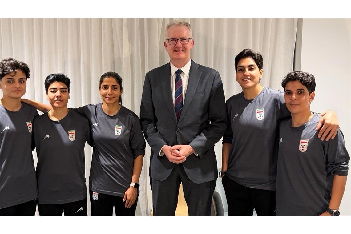 Australiens Innenminister Tony Burke (M) mit Spielerinnen des Irans.