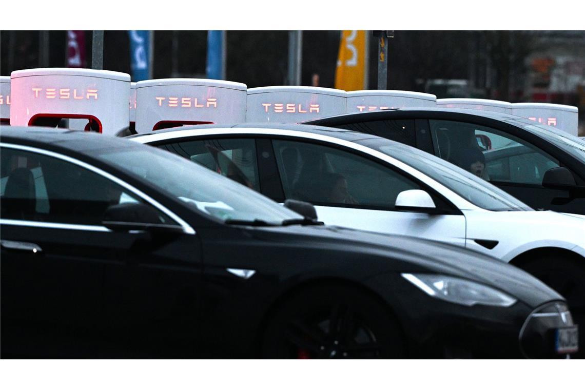 Fast 60 Prozent weniger Tesla-Autos in Deutschland neu zugelassen Autos stehen an den Säulen einer Tesla-Ladestation (Archivbild).