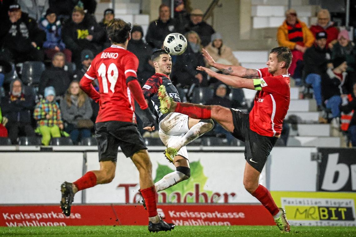 Für die TSG Backnang gibt’s Lob, für die SG Sonnenhof die drei Punkte Backnang und Mert Tasdelen (Mitte) lieferten sich mit Großaspachs Team um Kapitän Manuel Konrad (rechts) und Mittelfeldmann Fabian Benko ein enges Duell. Eines, bei dem es auf dem nassen und schmierigen Rasen viel Spannung und viel Kampf gab. Foto: Alexander Becher