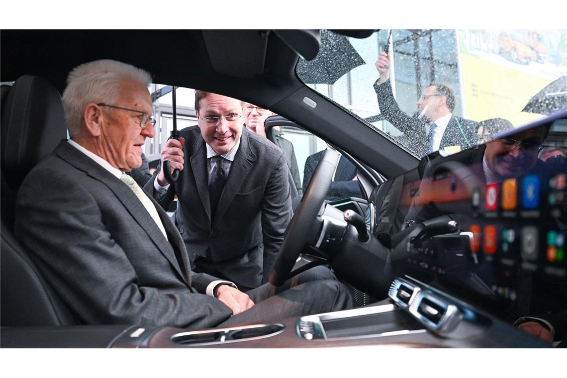 Baden-Württembergs Ministerpräsident Winfried Kretschmann bekommt das Cockpit eines Mercedes von Mercedes-Chef Ola Källenius erklärt.