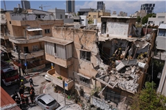 Beamte des israelischen Heimatfrontkommandos inspizieren ein Wohnhaus in Tel Aviv, das von einer iranischen Rakete getroffen wurde.