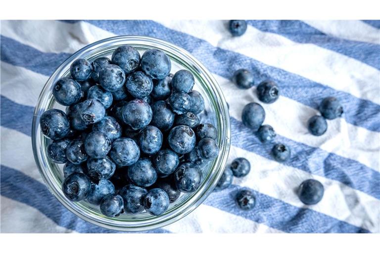 Beeren statt Chips oder Nüsschen: Heidelbeeren, auch Blaubeeren genannt, liegen auf einem Esstisch und werden gern gesnackt.
