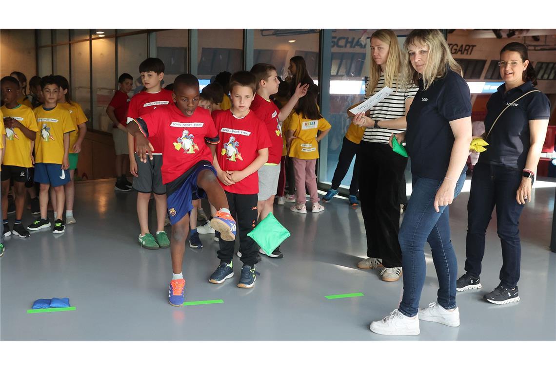 Bei der Affen-Station beweisen die Schüler ihre Geschicklichkeit. Mit dem Fuß soll das Sandsäckchen in den Reifen gekickt werden.