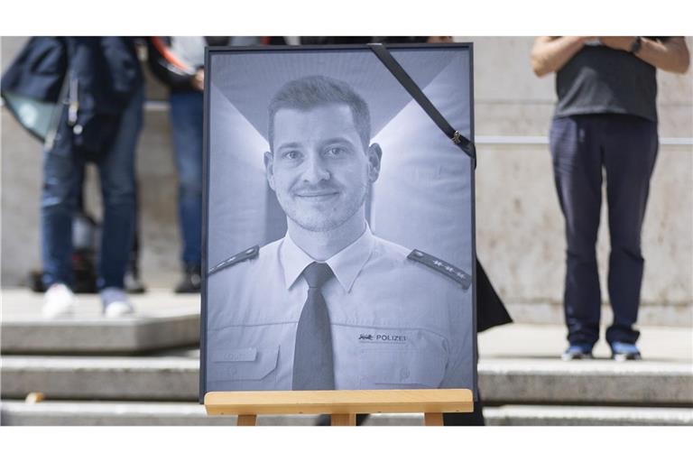 Bei der Trauerfeier auf dem Stuttgarter Rathausplatz haben Polizisten ein Bild ihres Kollegen Rouven Laur aufgestellt.