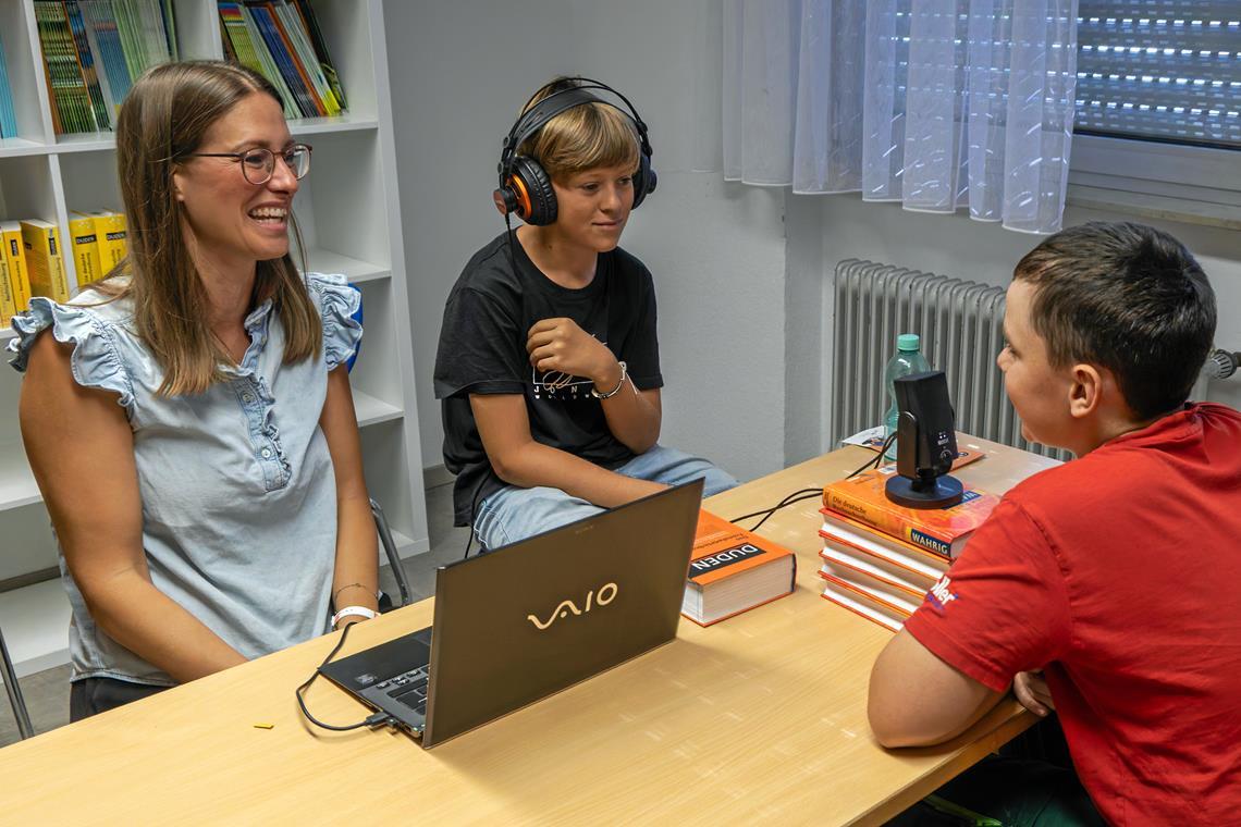 Podcastglück trifft Leseförderung Beim Produzieren der Podcastbausteine wird konzentriert gearbeitet, aber auch mal gelacht: Rene (von rechts) spricht Textabschnitte ein, Rafael hört bei der Aufnahme mit, um die Tonqualität zu kontrollieren, und Julia Dahlinger unterstützt und gibt Feedback. Foto: Stefan Bossow
