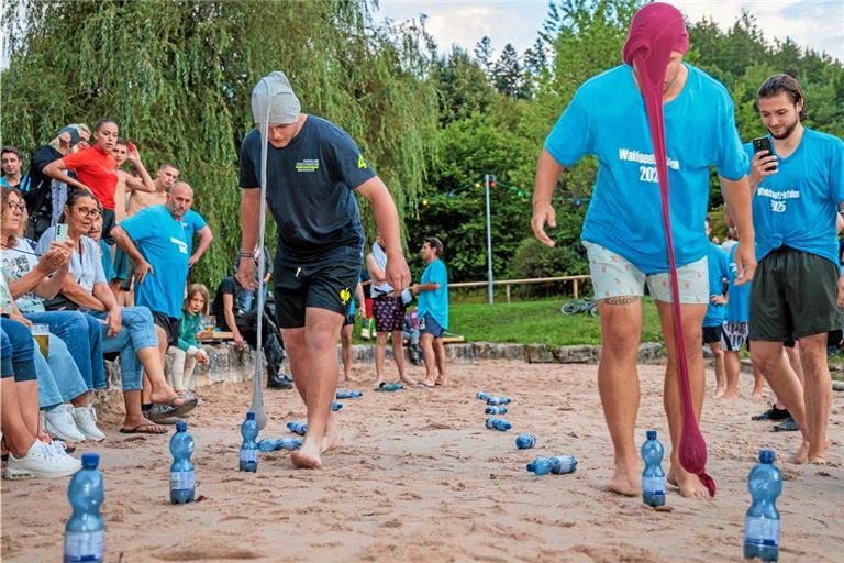 Beim „Strumpfkegeln“ müssen die Teilnehmenden des Waldseetriathlons Flaschen umwerfen – und zwar mit Gewichten, die in den Beinen einer Strumpfhose von ihrem Kopf herunterhängen. Fotos: Stefan Bossow